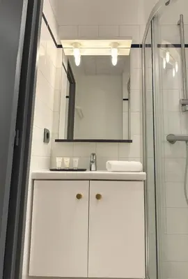a white bathroom with a sink and a mirror at Cosy Nest Near Center Chamonix in Chamonix-Mont-Blanc