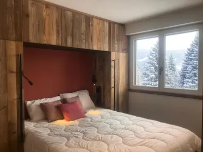 a large bed in a bedroom with two windows at Résidence Les Planes - Planes 2 MAE-5206 in Saint-Gervais-les-Bains