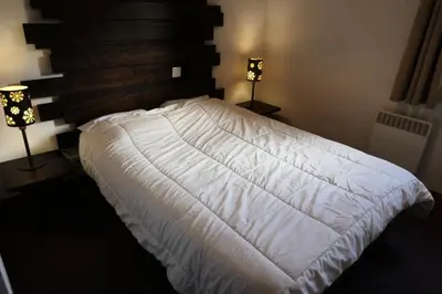 a white bed in a bedroom with two lamps at Résidence Les Fermes De Saint Gervais - Fermes de Saint Gervais B20 MAE-5220 in Saint-Gervais-les-Bains
