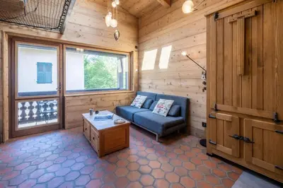 a living room with a blue couch and a table at Chalet Racar pour 4 personnes, centre ville et vue sur la montagne in Chamonix-Mont-Blanc
