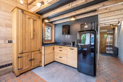 a kitchen with wooden cabinets and a refrigerator at Chalet Racar pour 4 personnes, centre ville et vue sur la montagne in Chamonix-Mont-Blanc