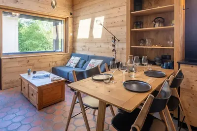 a dining room with a table and chairs and a couch at Chalet Racar pour 4 personnes, centre ville et vue sur la montagne in Chamonix-Mont-Blanc