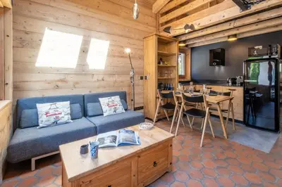 a living room with a blue couch and a table at Chalet Racar pour 4 personnes, centre ville et vue sur la montagne in Chamonix-Mont-Blanc