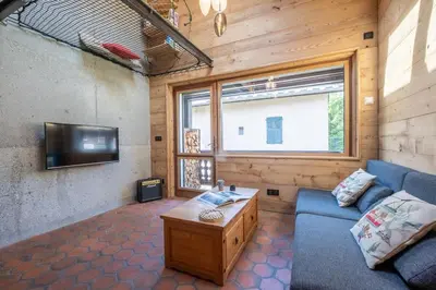 a living room with a blue couch and a tv at Chalet Racar pour 4 personnes, centre ville et vue sur la montagne in Chamonix-Mont-Blanc