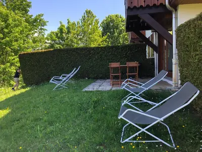 two chairs and a table in the grass at Petite Marmotte in Saint-Gervais-les-Bains