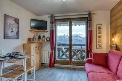 a living room with a couch and a large window at Studio Cosy coin-nuit proche centre - Vue splendide in Saint-Gervais-les-Bains