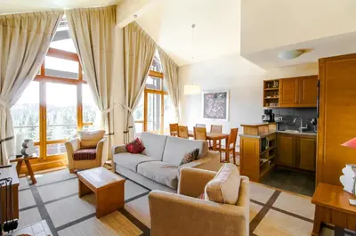 a living room with a couch and a kitchen at Private penthouse 2-bed Apartment, ski in and out in 5* Flaine Residence in Flaine