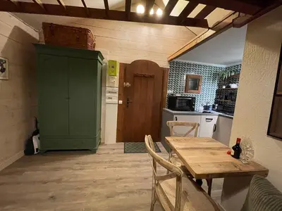 a kitchen with a wooden table and a green cabinet at Le Chalet du Petit Ours in Chamonix-Mont-Blanc