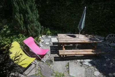 a picnic table with an umbrella and two chairs at Le Chalet du Petit Ours in Chamonix-Mont-Blanc