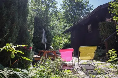 a group of three chairs sitting in a garden at Le Chalet du Petit Ours in Chamonix-Mont-Blanc