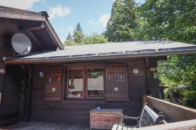 a wooden house with a porch and a window at Le Chalet du Petit Ours in Chamonix-Mont-Blanc
