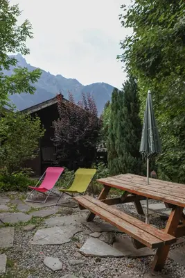 a picnic table and two chairs and an umbrella at Le Chalet du Petit Ours in Chamonix-Mont-Blanc