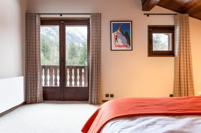 a bedroom with a bed and a window at Chalet Les Praz - 280sqm - Sauna Cinema Fitness - 5 Bedrooms in Heart of Les Praz - By Cozee Rentals in Chamonix-Mont-Blanc