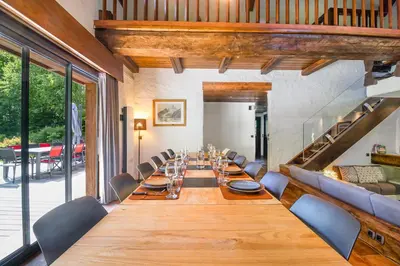 a long dining room with a long table and chairs at Chalet Les Praz - 280sqm - Sauna Cinema Fitness - 5 Bedrooms in Heart of Les Praz - By Cozee Rentals in Chamonix-Mont-Blanc