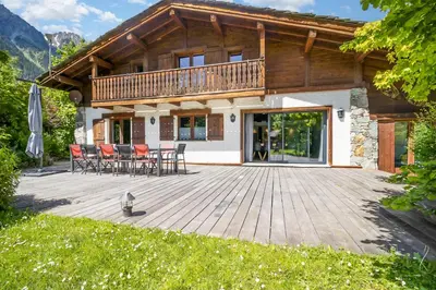 a wooden house with a door and a mountain at Chalet Les Praz - 280sqm - Sauna Cinema Fitness - 5 Bedrooms in Heart of Les Praz - By Cozee Rentals in Chamonix-Mont-Blanc