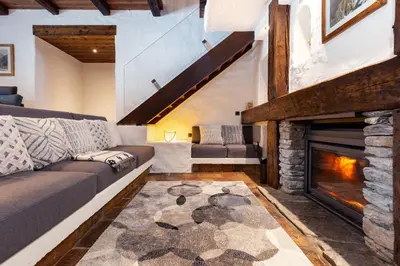 a living room with a couch and a fireplace at Chalet Les Praz - 280sqm - Sauna Cinema Fitness - 5 Bedrooms in Heart of Les Praz - By Cozee Rentals in Chamonix-Mont-Blanc