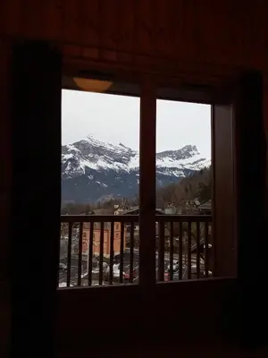 a view of a snow covered mountain from a window at Spacious and comfortable chalet apartment. in Saint-Gervais-les-Bains