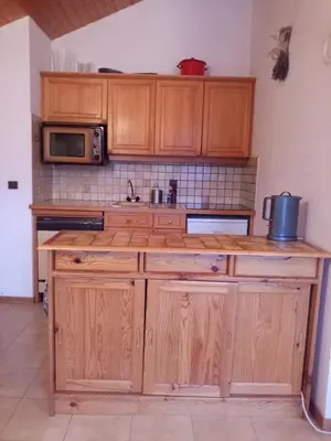 a kitchen with wooden cabinets and a microwave at Spacious and comfortable chalet apartment. in Saint-Gervais-les-Bains
