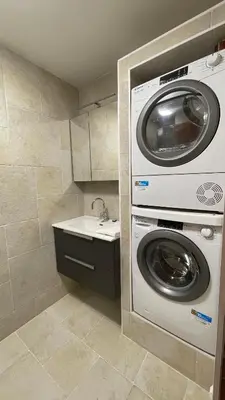 a washer and dryer in a bathroom with a sink at Les Comtes de Savoie - Appartement rénové proche du centre de Megève avec vue sur le Mont d'Arbois in Megève
