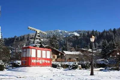 a red train car in the snow next to a street light at Les Comtes de Savoie - Appartement rénové proche du centre de Megève avec vue sur le Mont d'Arbois in Megève