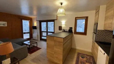a living room with a kitchen and a living room with a couch at Les Comtes de Savoie - Appartement rénové proche du centre de Megève avec vue sur le Mont d'Arbois in Megève