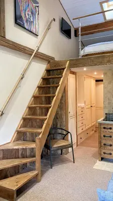 a staircase in a room with a chair and a table at Oree Studio Mezzanine in Megève