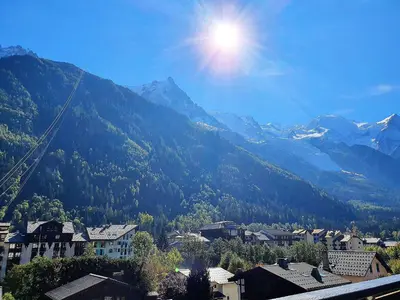 a view of a mountain range with a town and houses at Duplex avec sauna et vue Mont Blanc au centre de Chamonix in Chamonix-Mont-Blanc