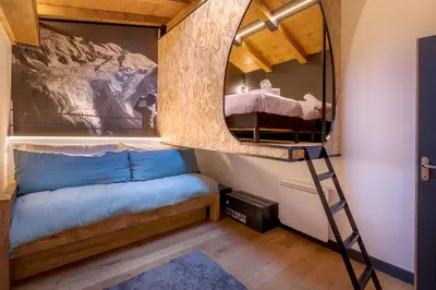 a bedroom with a bunk bed and a mirror at Duplex avec sauna et vue Mont Blanc au centre de Chamonix in Chamonix-Mont-Blanc