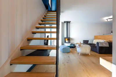 a staircase in a house with a living room at Duplex avec sauna et vue Mont Blanc au centre de Chamonix in Chamonix-Mont-Blanc