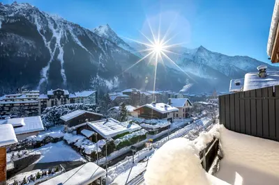 a city covered in snow with mountains in the background at Duplex avec sauna et vue Mont Blanc au centre de Chamonix in Chamonix-Mont-Blanc