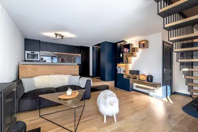 a living room with a couch and a table at Duplex avec sauna et vue Mont Blanc au centre de Chamonix in Chamonix-Mont-Blanc