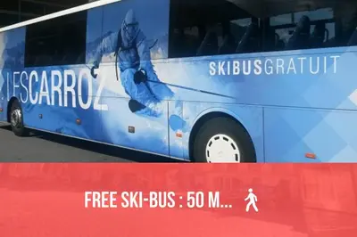a blue bus with an advertisement on the side of it at GREEN APPLE CARROZ Duplex WIFI Garage Balcon-Sud Vue Montagne in Les Carroz d'Araches