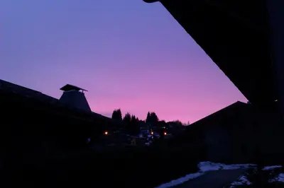 a purple and pink sky with a windmill at Les Carroz Alpine Chalet - central in Les Carroz d'Araches