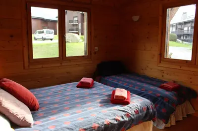 a bedroom with two beds in a log cabin at Les Carroz Alpine Chalet - central in Les Carroz d'Araches