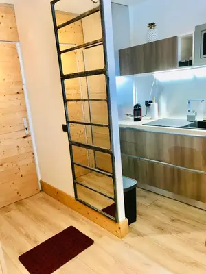 a kitchen with a ladder in the corner of a room at In The City Center With A View Of Mont Blanc in Chamonix-Mont-Blanc