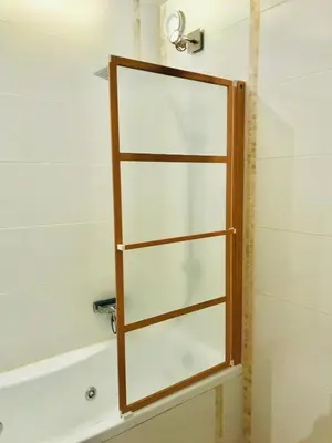 a glass shower door in a bathroom with a tub at In The City Center With A View Of Mont Blanc in Chamonix-Mont-Blanc