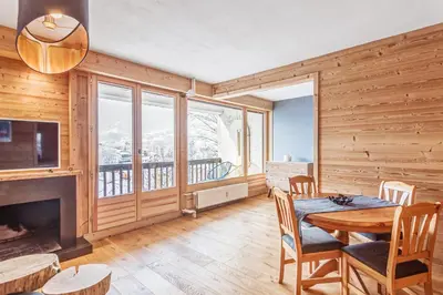 a dining room with a table and a fireplace at Appartement Mazot - Welkeys in Megève