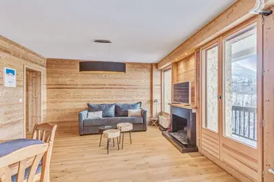 a living room with a couch and a television at Appartement Mazot - Welkeys in Megève