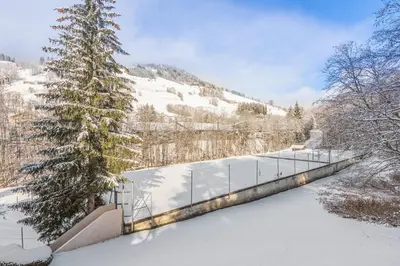 a fence in the snow next to a tree at Appartement Mazot - Welkeys in Megève