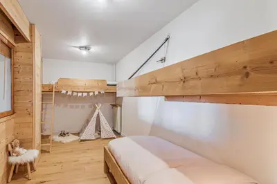 a bedroom with a bunk bed and a ladder at Appartement Mazot - Welkeys in Megève