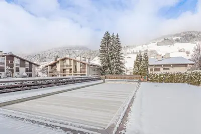 a snow covered sidewalk with buildings and trees at Appartement Mazot - Welkeys in Megève