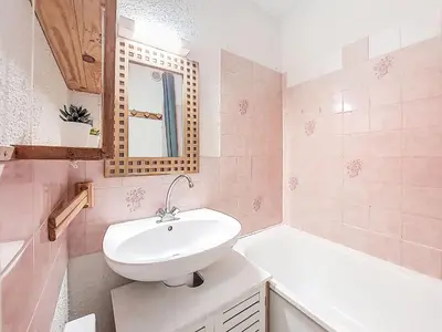 a pink bathroom with a sink and a bath tub at Apartment Pierres Blanches F et H-10 by Interhome in Le Cugnon