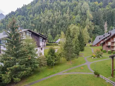 a ski lodge with a snow covered mountain in the background at Apartment Pierres Blanches F et H-10 by Interhome in Le Cugnon