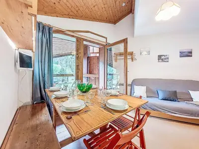 a kitchen with a wooden table with red chairs at Apartment Pierres Blanches F et H-10 by Interhome in Le Cugnon