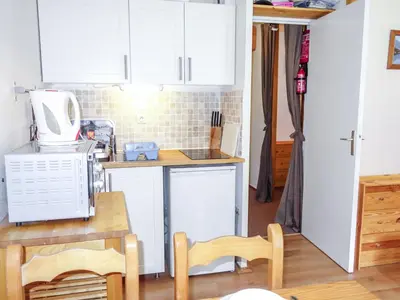 a kitchen with white cabinets and a table and a microwave at Studio L'Enclave I et J-28 by Interhome in Les Contamines-Montjoie