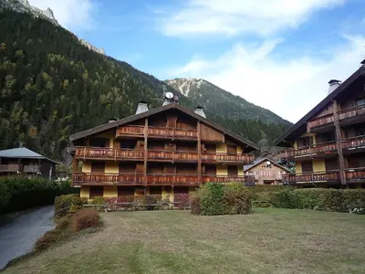 a large wooden building with a grass yard in front at Apartment Les Capucins by Interhome in Chamonix-Mont-Blanc