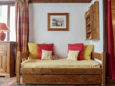 a couch with red and yellow pillows in a room at Studio Lognan-1 by Interhome in Chamonix-Mont-Blanc