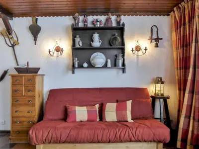 a red couch in a room with a shelf at Studio Lognan-1 by Interhome in Chamonix-Mont-Blanc