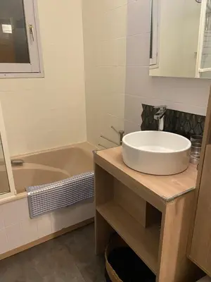 a bathroom with a sink and a tub at Appartement lumineux et cosy en rez de jardin in Saint-Gervais-les-Bains