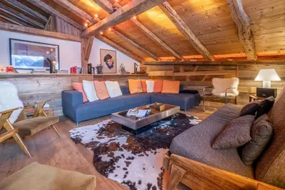a living room with a blue couch and a table at Authenthic Chalet Ski on Les Houches Chamonix in Les Houches